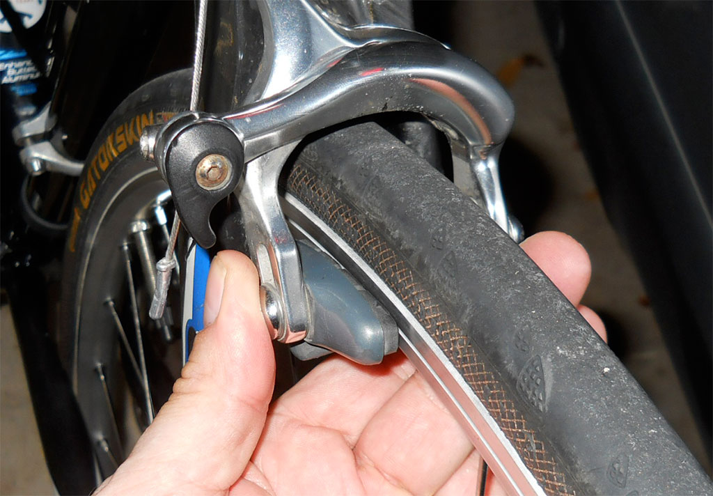 Squeeze the calipers until they almost touch the rim.