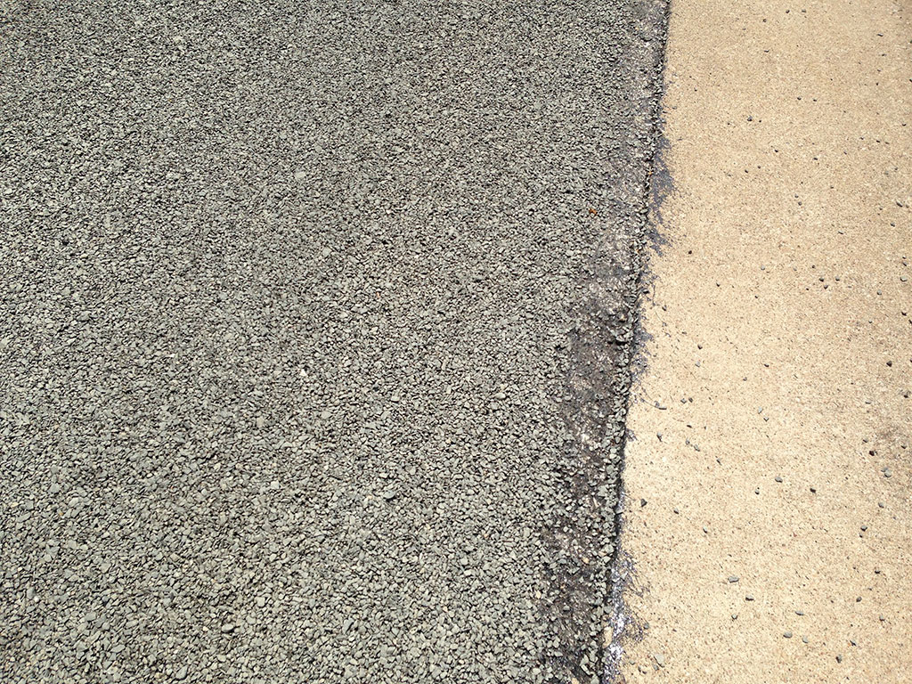 The dreaded chip sealed surface. Loose gravel will cover the road for some time to come.