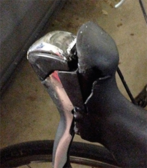It's easy to see how the hood separates from the top of the brake lever. A tear is visible, too. (Click pix to enlarge.)